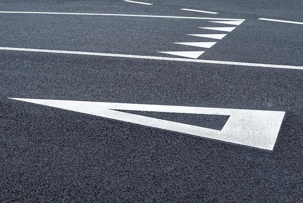 What does a white triangle painted on the road mean? 